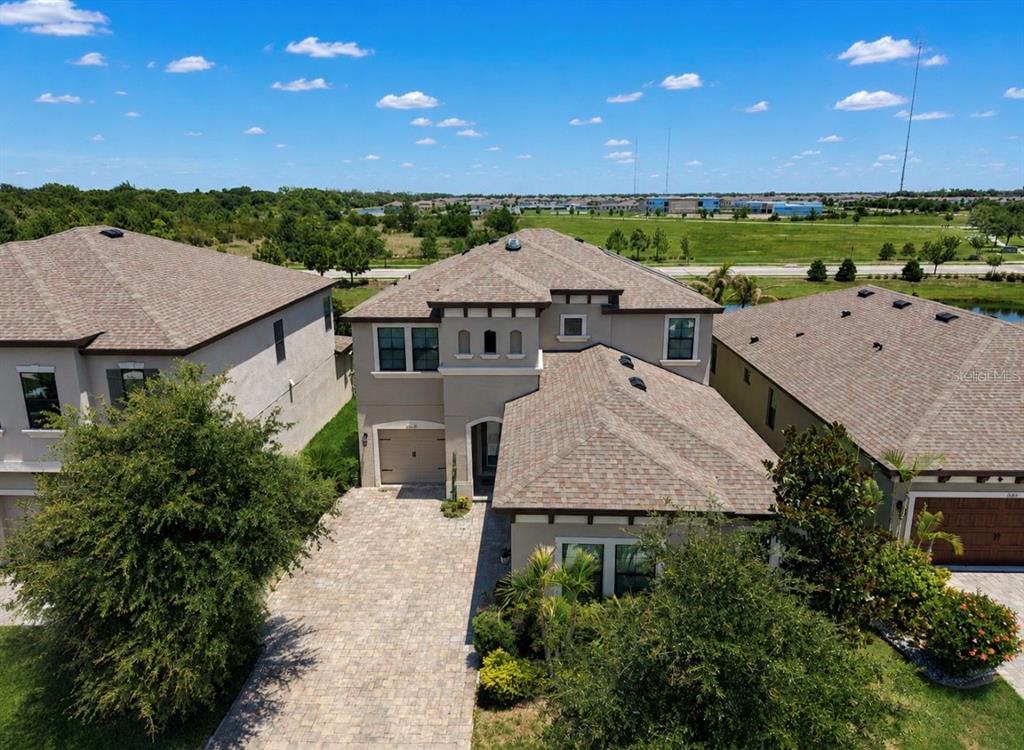 An aerial view of a two-story suburban house with a paved driveway and shingled roof — 13107 MONACH ISLES DRIVE, RIVERVIEW, FL