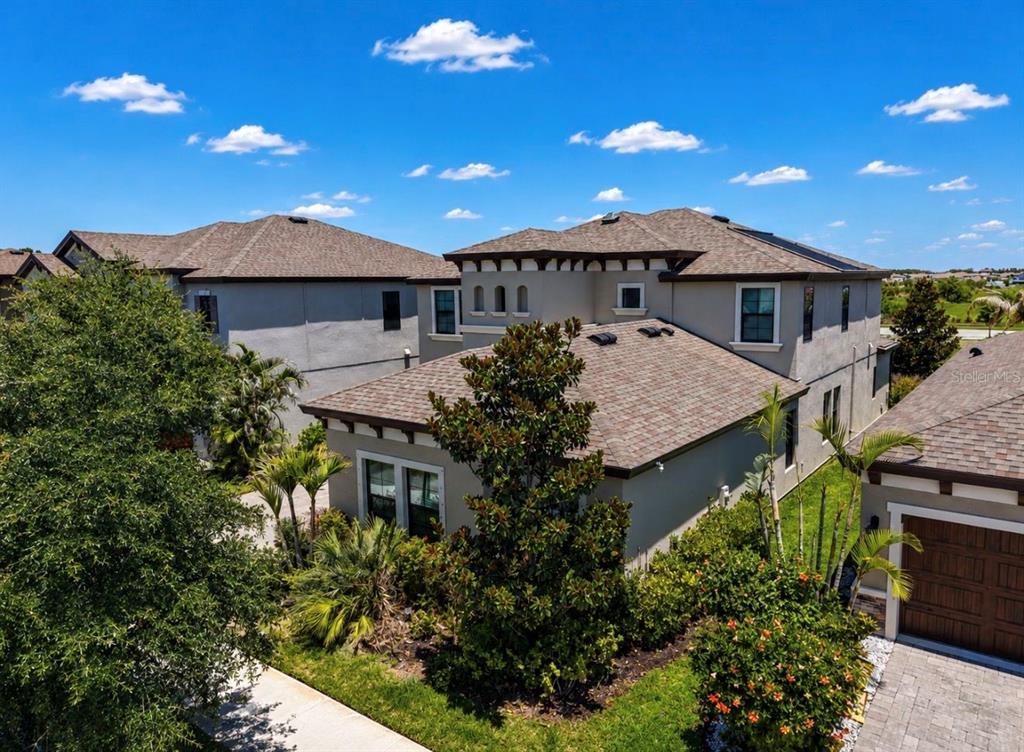 An aerial view of a two-story suburban house with a shingled roof and landscaping — 13107 MONACH ISLES DRIVE, RIVERVIEW, FL