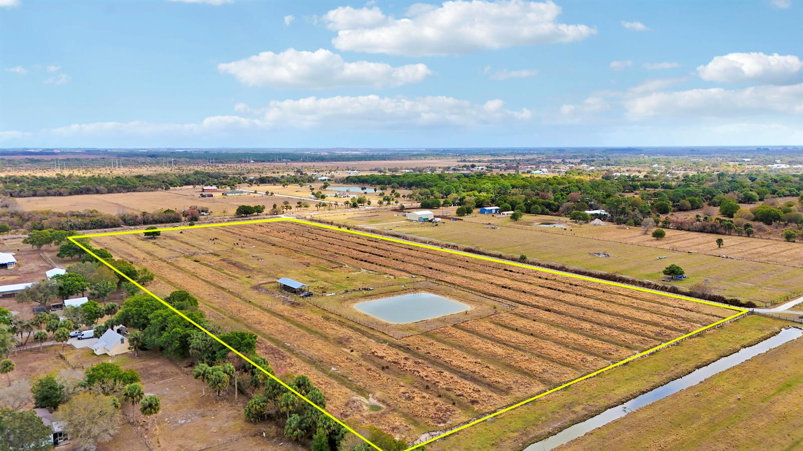 An aerial view shows a large, fenced rectangular pasture featuring a pond and small shed — Tbd S Brocksmith Road, Fort Pierce FL 34945, FORT PIERCE, FL