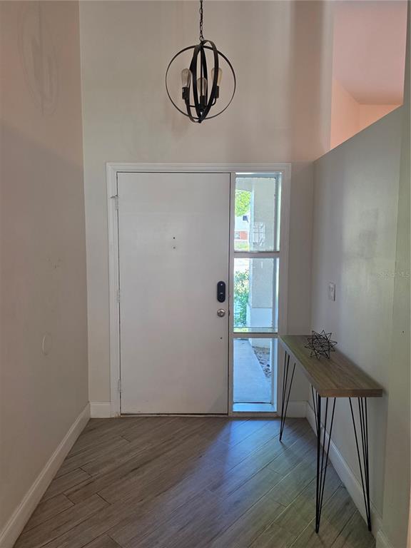 An entryway features a white door, a side window, a pendant light, and a console table — 10158 BRANDON CIRCLE, ORLANDO, FL