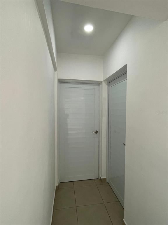 A narrow hallway features white walls, tiled flooring, and two white doors — CARR 416 INT CALLE C UNIT 1, AGUADA, PR
