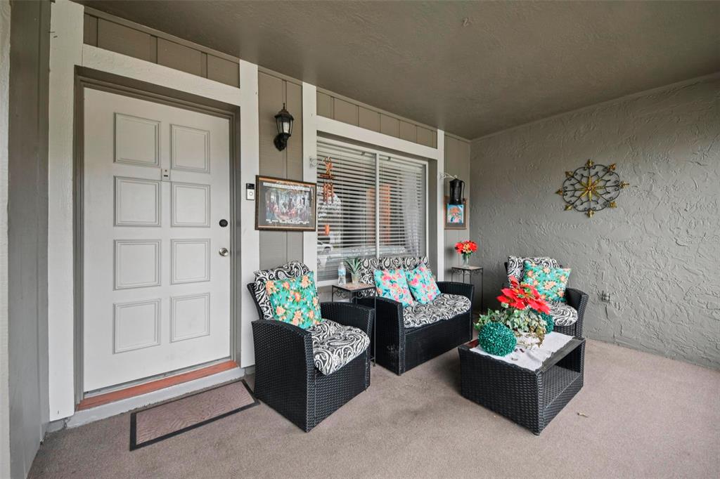 A covered patio features black wicker furniture with floral cushions and a matching coffee table — 10407 LARISSA STREET, ORLANDO, FL