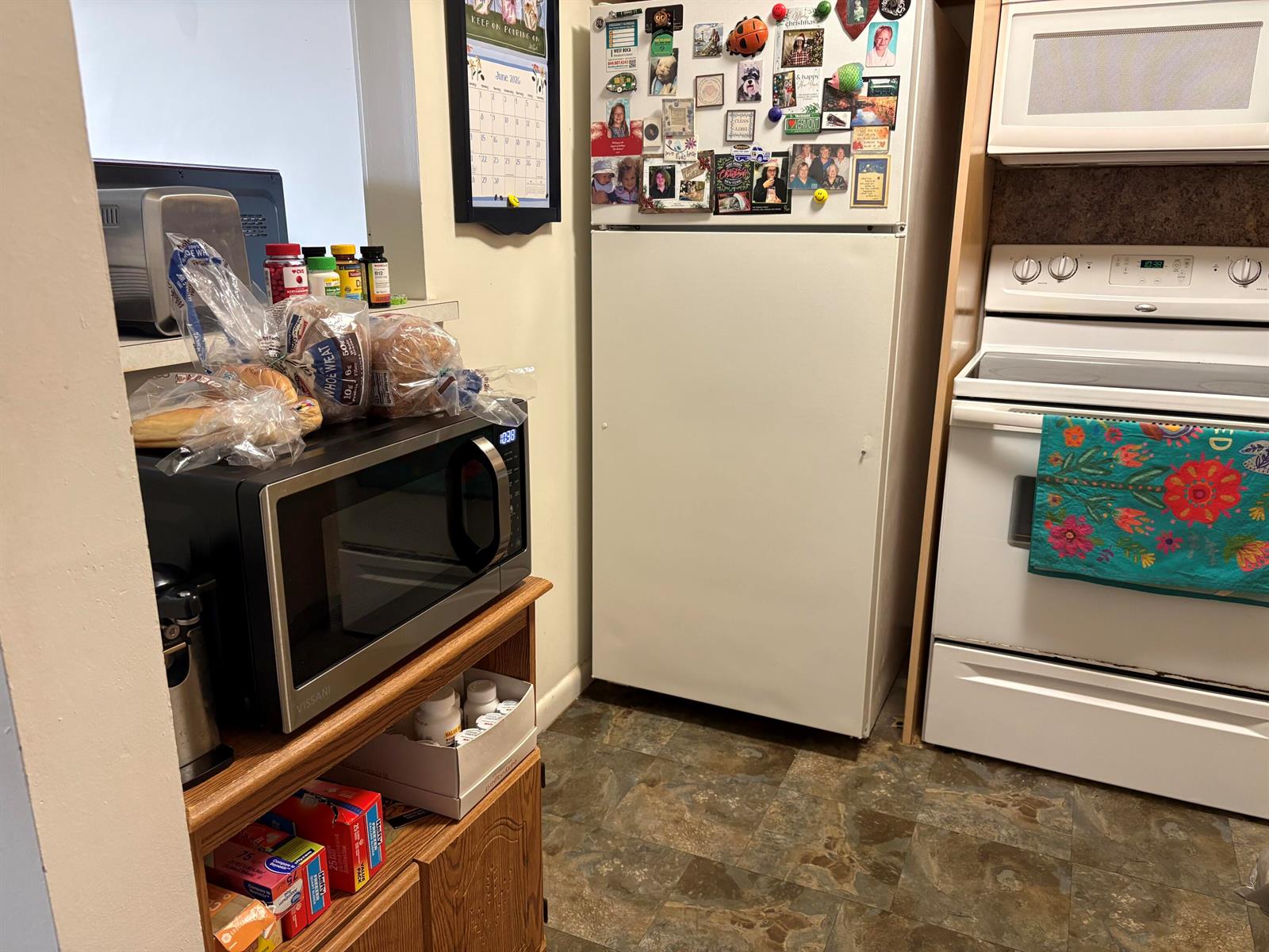 A kitchen features a microwave on a wooden stand, a white refrigerator, and a stove — 314 Preston H, Boca Raton FL 33434, BOCA RATON, FL