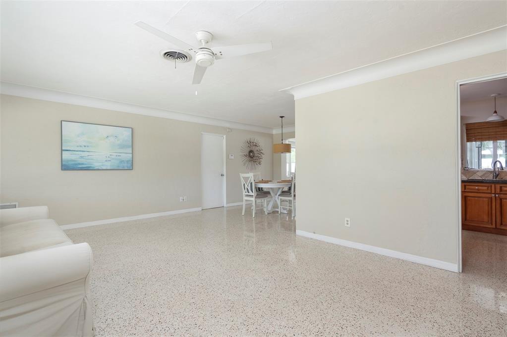 A living room with terrazzo flooring, a ceiling fan, and an adjacent dining area — 6355 23RD AVENUE N, ST PETERSBURG, FL
