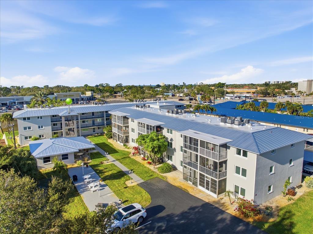 An aerial view of a multi-story apartment complex with a central courtyard and parking area — 649 TAMIAMI TRAIL S UNIT 306, VENICE, FL