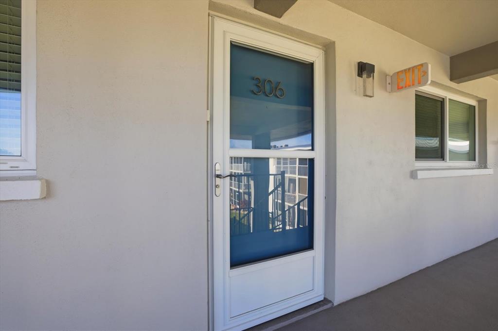 A white door with the number 306 is set in a beige exterior wall — 649 TAMIAMI TRAIL S UNIT 306, VENICE, FL