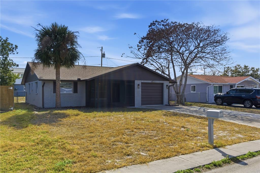 A single-story house with a brown roof, dark siding, and a screened-in front porch — 5330 POINSETTIA DR, NEW PORT RICHEY, FL