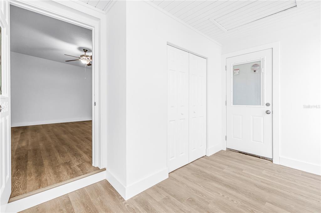 A bright entryway features light wood-look flooring, a white closet, and a door with glass — 110 NE MONROE CIRCLE N, ST PETERSBURG, FL