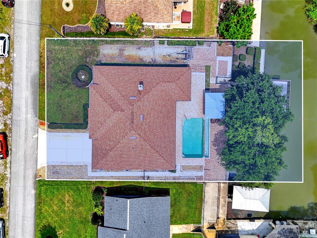 An aerial view shows a house with a brown roof, a swimming pool, and a dock — 108 GODFREY ROAD, EDGEWATER, FL