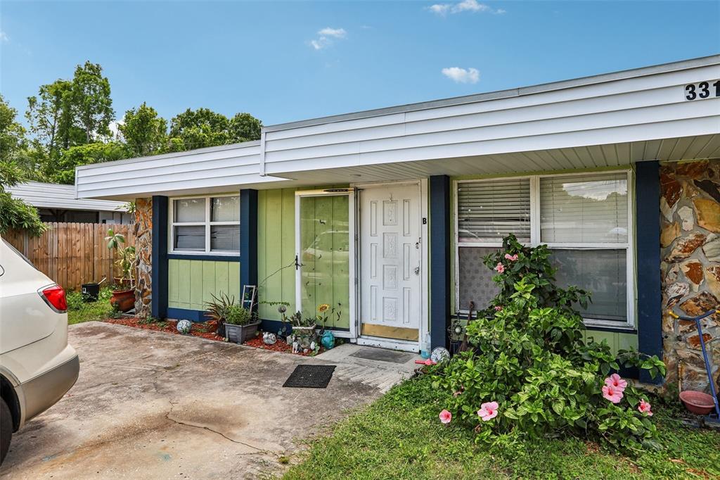 A single-story residence with a white door, light green siding, and stone accents — 3319 SHERWOOD DRIVE, LARGO, FL