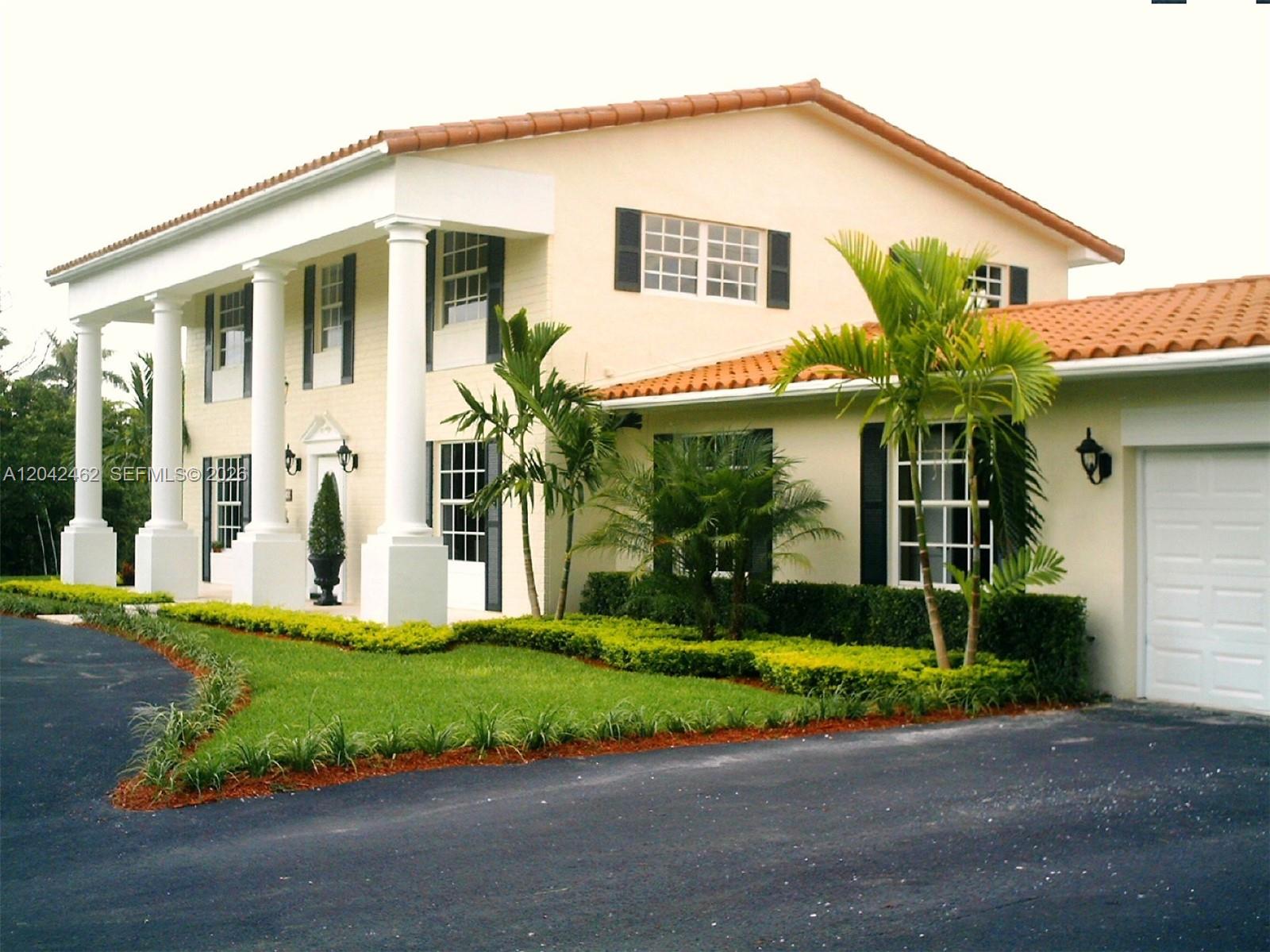 A two-story house with white columns, a tiled roof, and a paved driveway — 7240 SW 119th St, Pinecrest FL 33156, PINECREST, FL