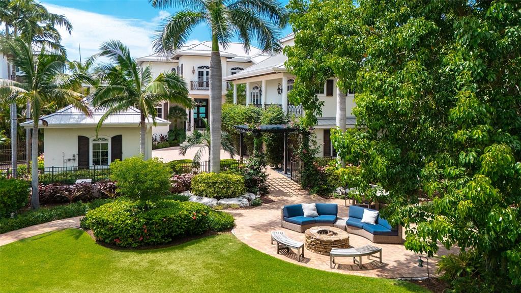 A large house with a patio, fire pit, and seating area in a landscaped yard — 1435 WESTWAY DRIVE, SARASOTA, FL