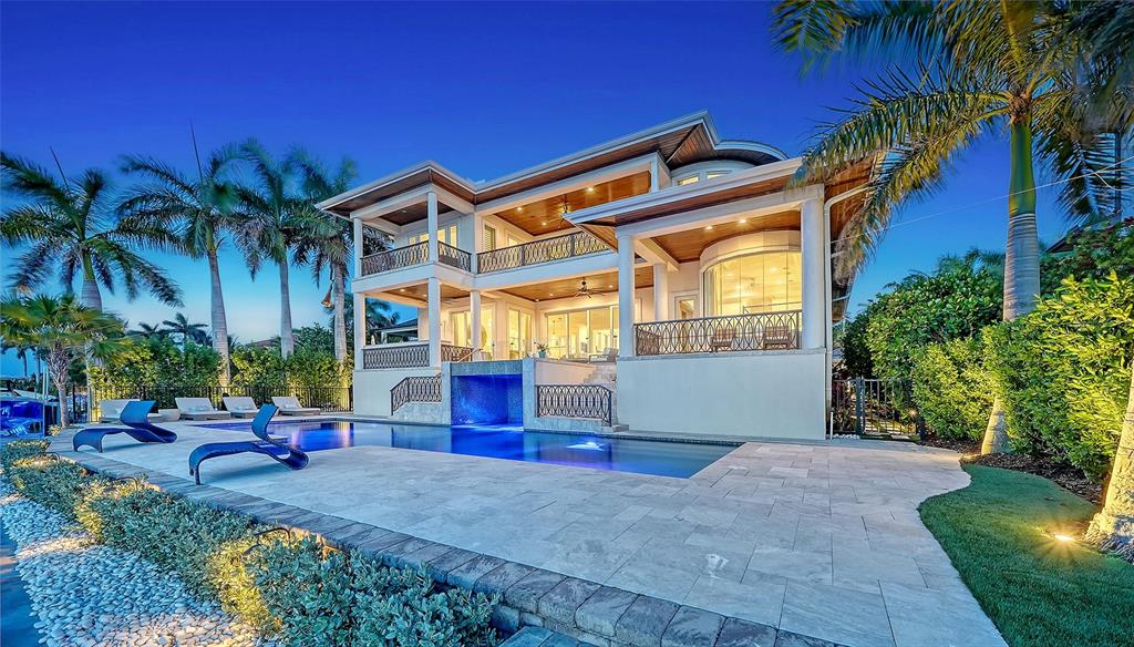 A two-story luxury home features a swimming pool, stone patio, and palm trees at dusk — 1435 WESTWAY DRIVE, SARASOTA, FL