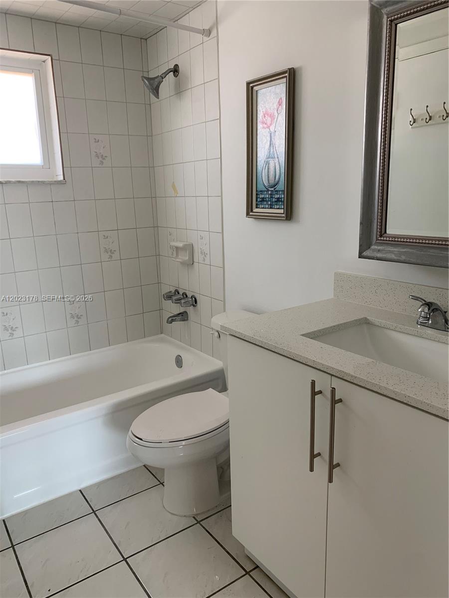 A bathroom features a white vanity, a toilet, and a tiled shower-tub combination — 7703 Camino Real # 405, Miami FL 33143, MIAMI, FL