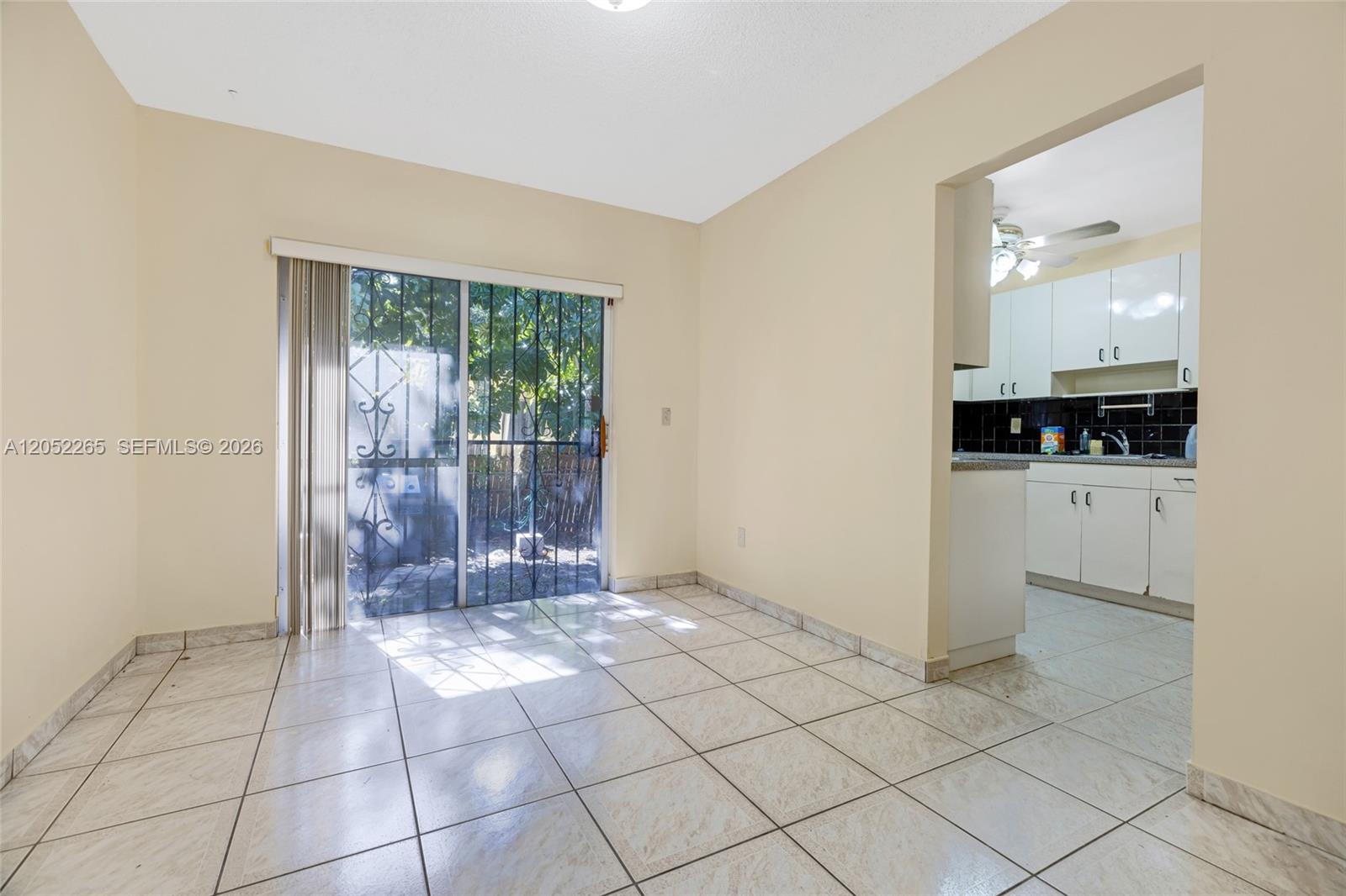 A dining area with tile flooring and a sliding glass door leads to a patio — 16420 NE 5th Ave # 000, Miami FL 33162, MIAMI, FL