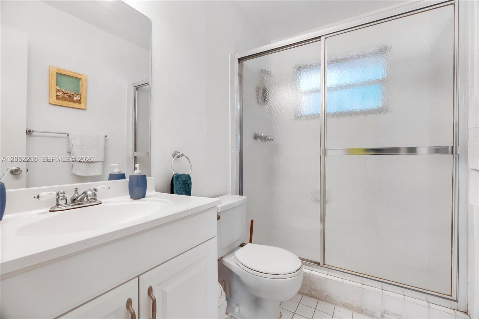 A bathroom features a white vanity, a toilet, and a glass-enclosed shower — 16420 NE 5th Ave # 000, Miami FL 33162, MIAMI, FL