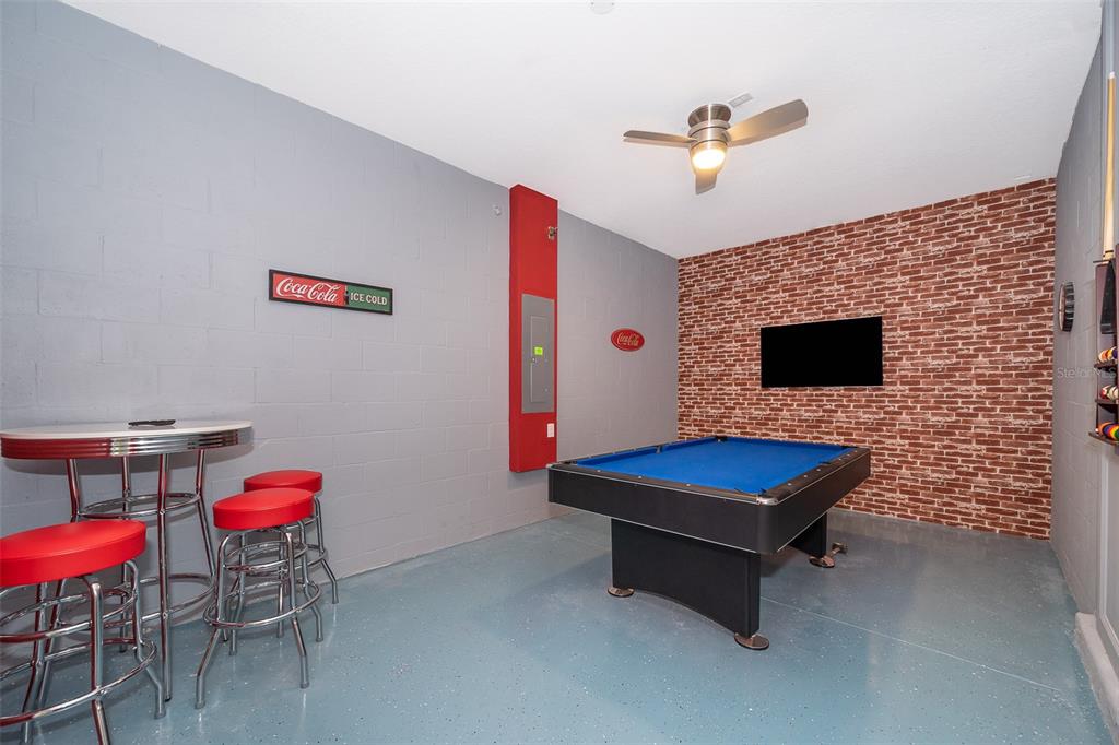 A game room features a blue pool table, a retro bistro set, and brick-patterned wallpaper — 2744 BOOKMARK DRIVE, KISSIMMEE, FL