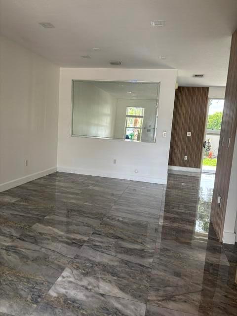 A room with glossy, marbled tile flooring and a large rectangular wall mirror — 254 Riverwalk Circle # 254, Sunrise FL 33326, SUNRISE, FL