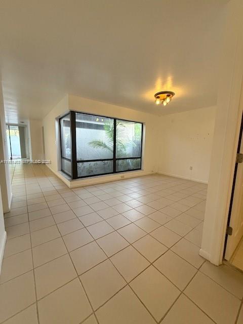 An open brown door reveals a tiled interior room with a large window — 13371 SW 89th Ter # F, Miami FL 33186, MIAMI, FL
