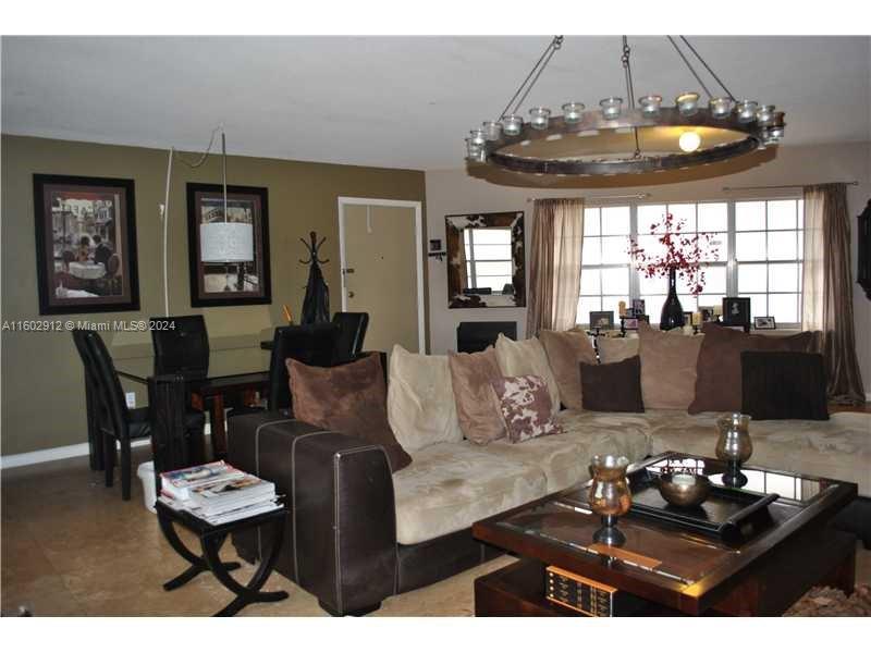 A living room features a large sectional sofa, a coffee table, and a circular chandelier — 11855 NE 19th Dr # 1, North Miami FL 33181, NORTH MIAMI, FL