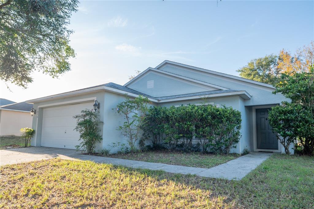 A single-story house with a light blue exterior, a two-car garage, and a front walkway — 1836 RIDGE VALLEY STREET, CLERMONT, FL