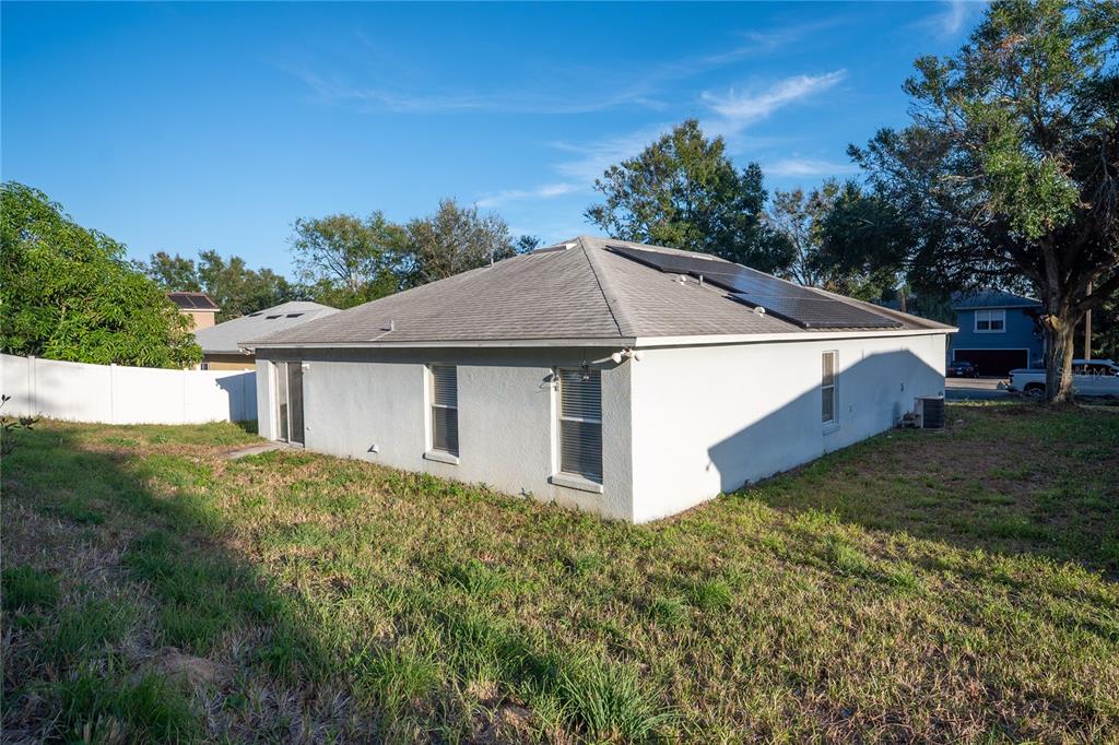 The exterior of a single-story house with a hip roof and solar panels — 1836 RIDGE VALLEY STREET, CLERMONT, FL