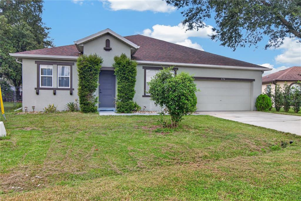 A single-story house with a gray exterior, a two-car garage, and a front lawn — 626 BALDWIN DRIVE, KISSIMMEE, FL