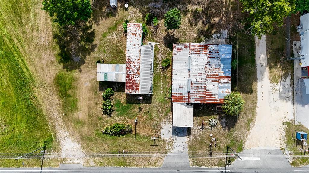 An aerial view shows two structures with weathered metal roofs on a rural lot — 12818 NE OLD JACKSONVILLE ROAD, ANTHONY, FL