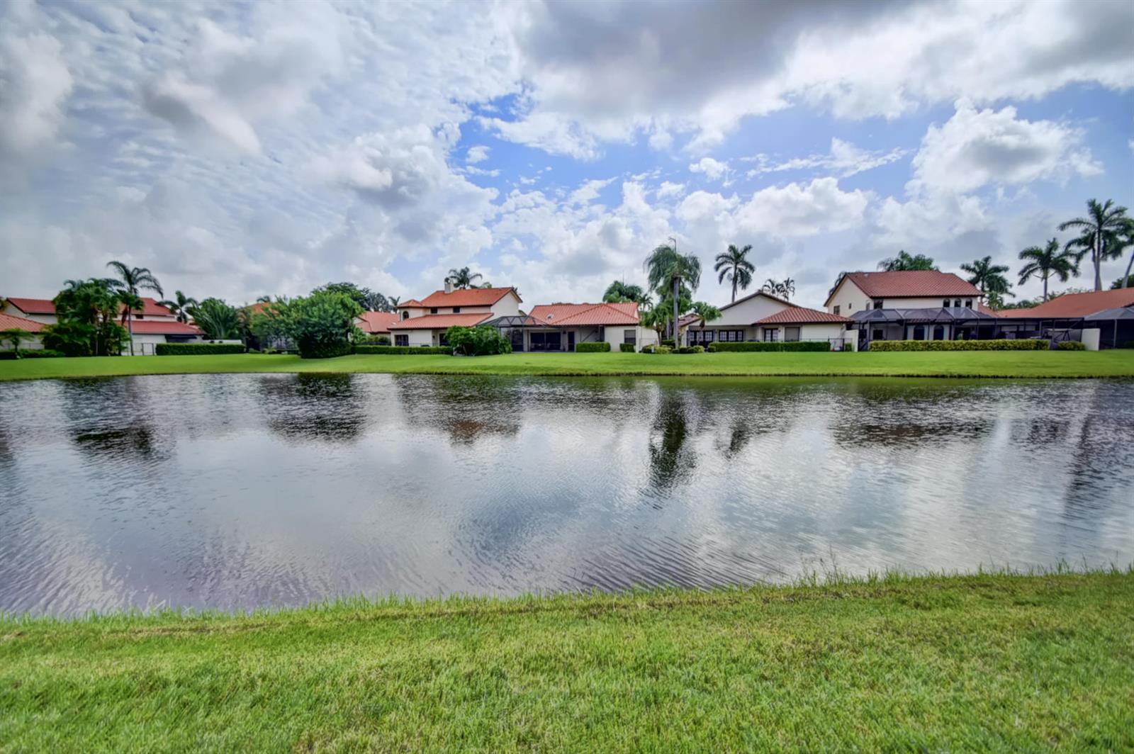 A pond sits in front of a row of houses with red tile roofs — 22595 Esplanada Circle W, Boca Raton FL 33433, BOCA RATON, FL