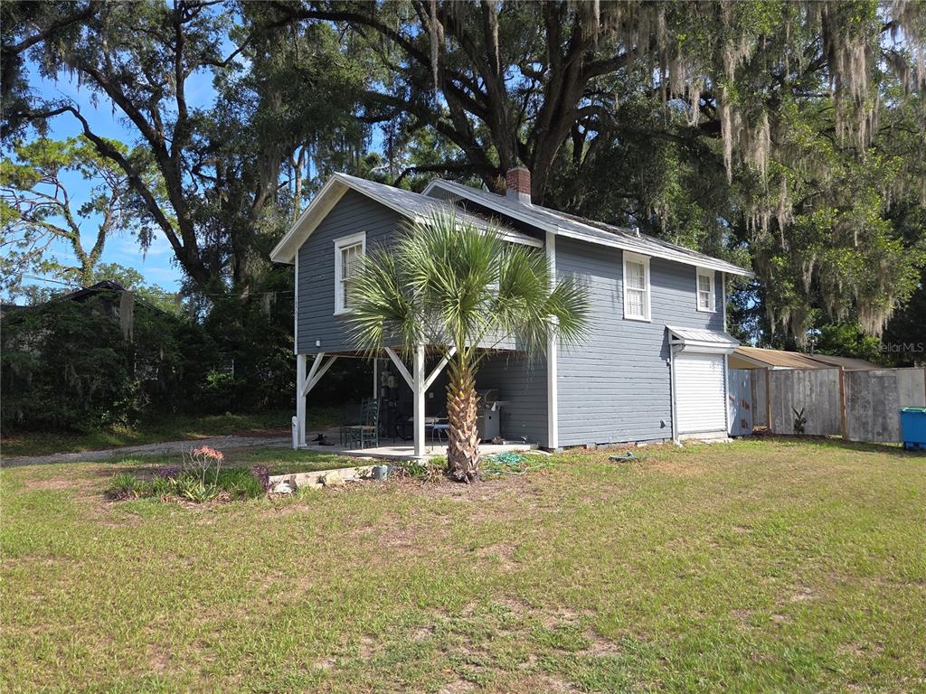 A two-story gray house with a raised porch and a palm tree in the yard — 18758 NW 243RD TERRACE, HIGH SPRINGS, FL