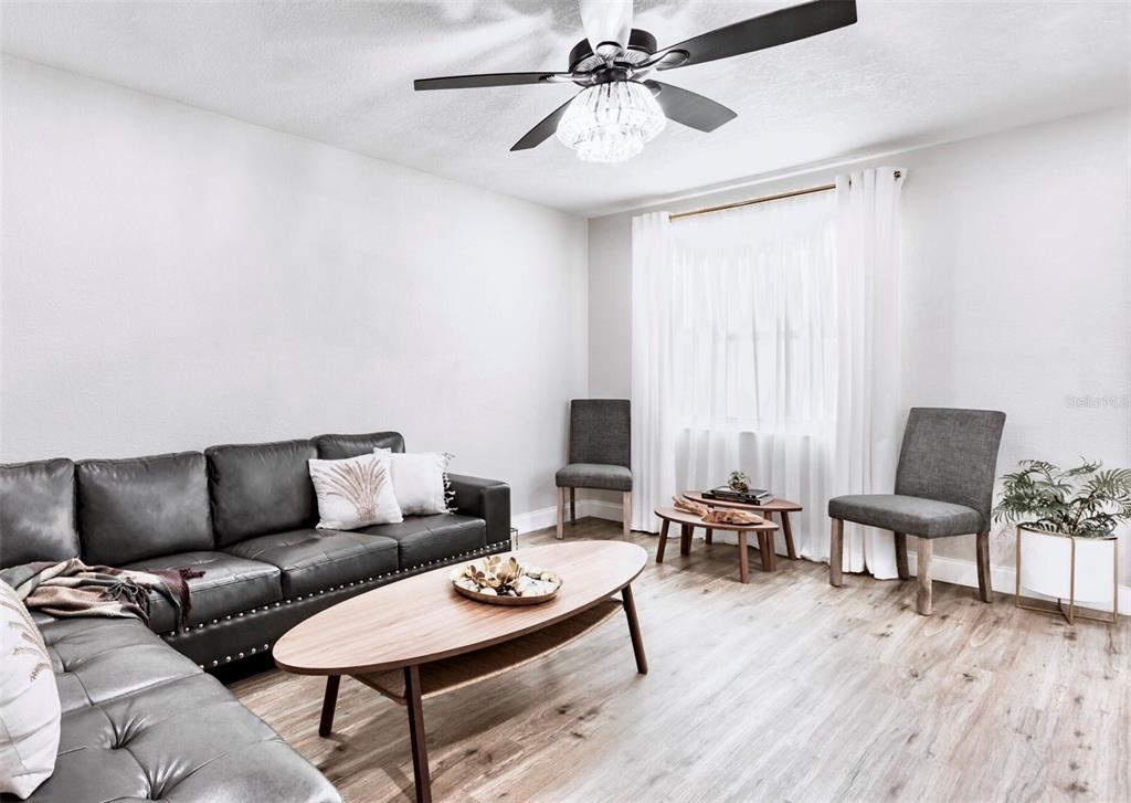 A living room features a gray sectional sofa, a wooden coffee table, and two chairs — 6220 INTERBAY, TAMPA, FL