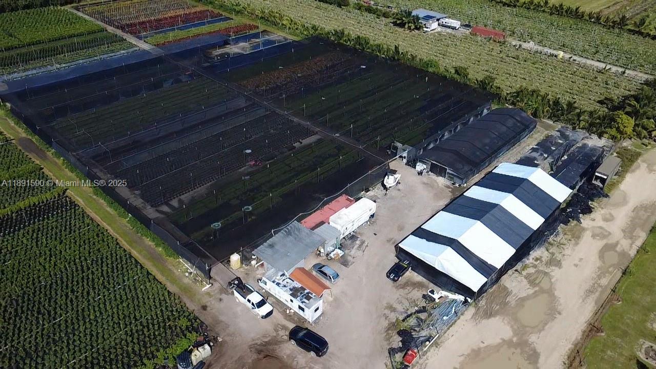 An aerial view shows a large agricultural property with greenhouses, outbuildings, and parked vehicles — krome, Homestead FL 33034, HOMESTEAD, FL