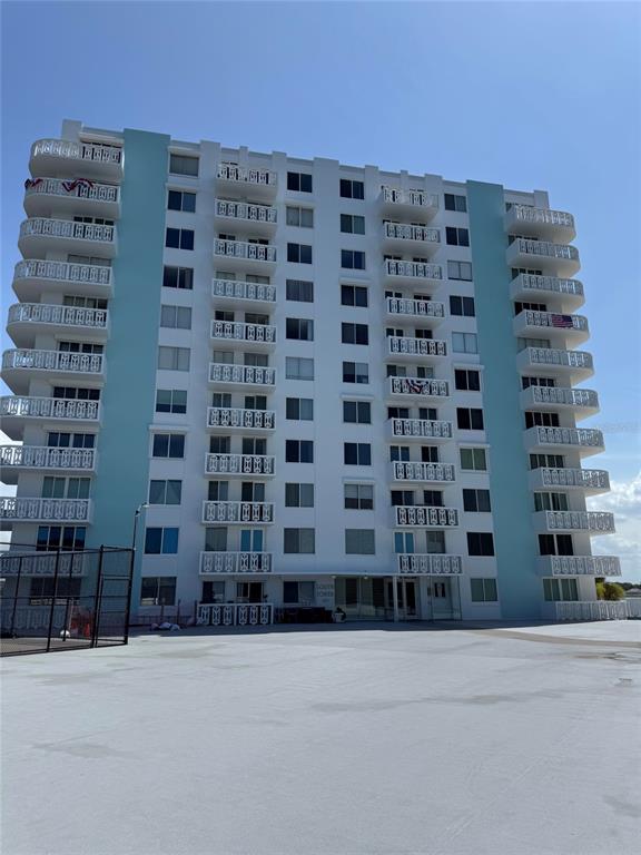 A multi-story apartment building with white balconies and light blue accent panels — 925 N HALIFAX AVENUE UNIT 102, DAYTONA BEACH, FL