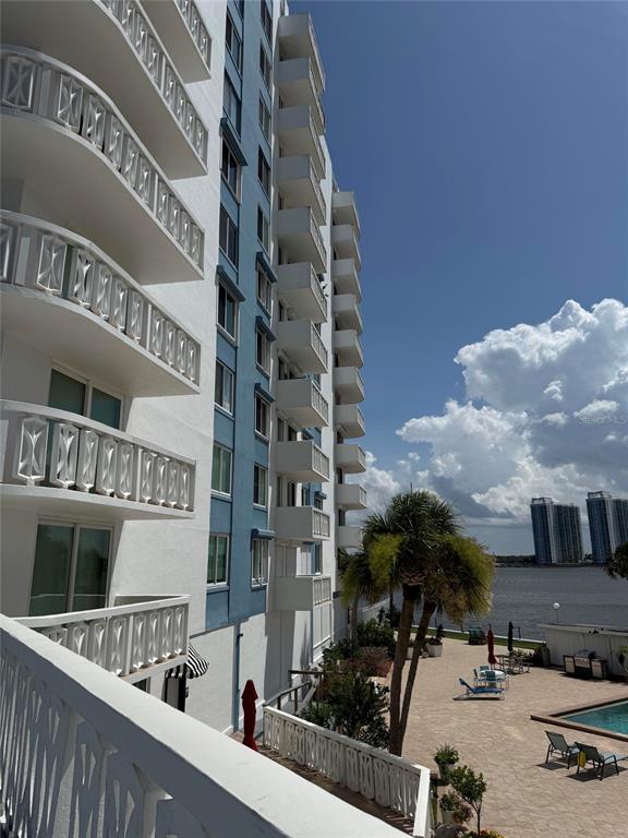 Exterior view of a multi-story apartment building with balconies overlooking a pool and water — 925 N HALIFAX AVENUE UNIT 102, DAYTONA BEACH, FL