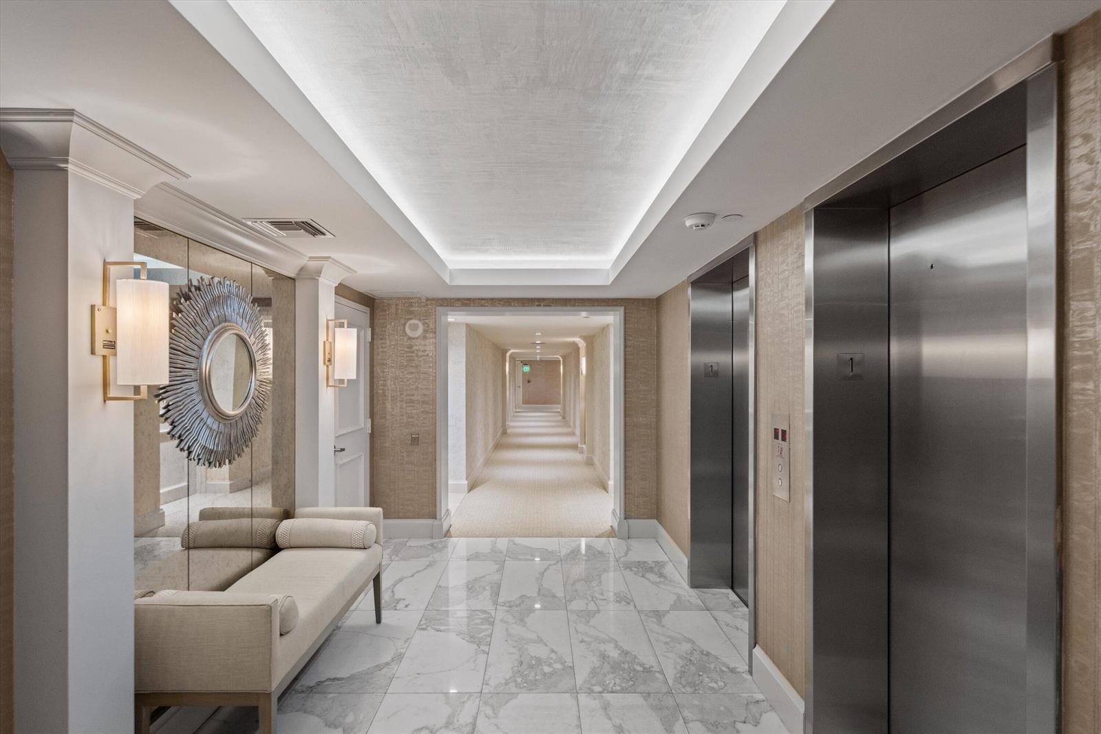 A hotel hallway features marble floors, a bench, mirrored walls, and two stainless steel elevators — 3440 S Ocean Boulevard, Palm Beach FL 33480, PALM BEACH, FL