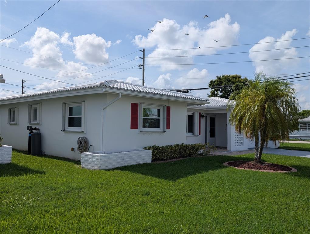 A white single-story house with red shutters and a palm tree in the front yard — 10188 45TH STREET N UNIT 2, PINELLAS PARK, FL