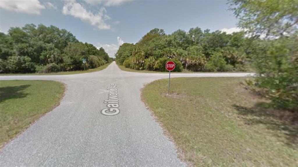 An outdoor view of a rural intersection with a stop sign and a paved road — 14088 GAILWOOD AVENUE, PORT CHARLOTTE, FL