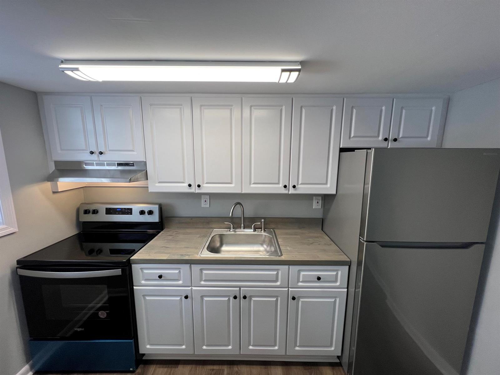 A kitchen features white cabinets, a stainless steel sink, a black stove, and a refrigerator — 2561 NW 135th Street # 3, Opa-Locka FL 33167, OPA-LOCKA, FL