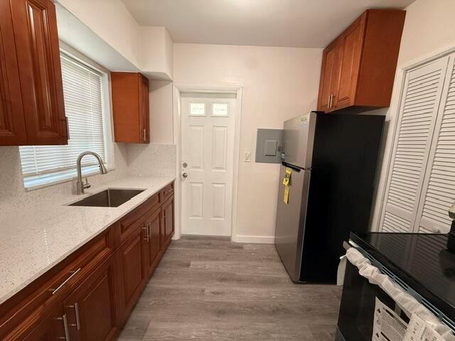 A kitchen features wood cabinets, white countertops, a stainless steel sink, and a black refrigerator — 2802 SW 36th Avenue, Miami FL 33133, MIAMI, FL