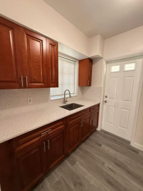 A kitchen features cherry wood cabinets, white speckled countertops, a stainless sink, and gray flooring — 2802 SW 36th Avenue, Miami FL 33133, MIAMI, FL