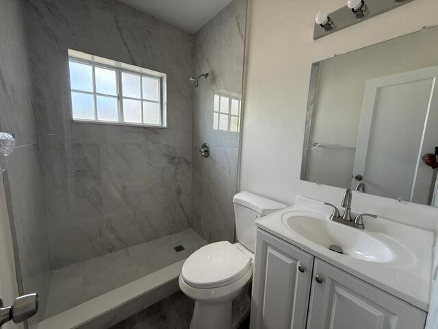 A bathroom features a walk-in shower with marble-look tile, a white toilet, and a vanity — 2802 SW 36th Avenue, Miami FL 33133, MIAMI, FL