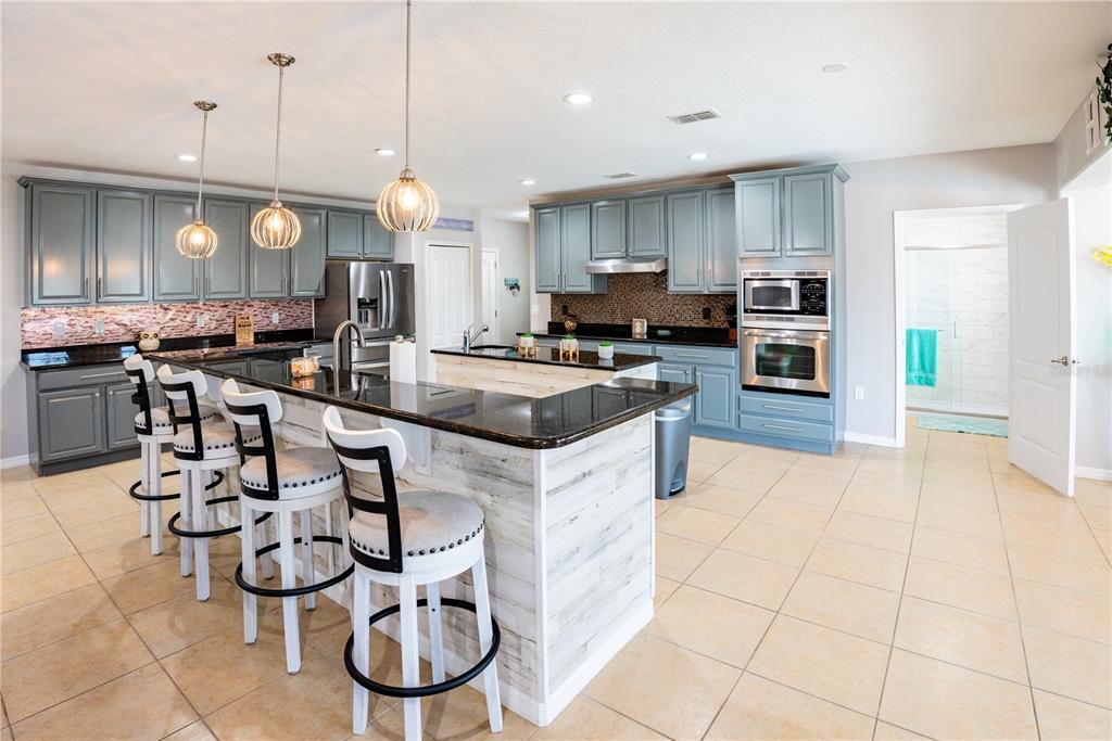 A two-story suburban house with a three-car garage and a front-facing palm tree — 493 HOLLOW GLEN DRIVE, TITUSVILLE, FL