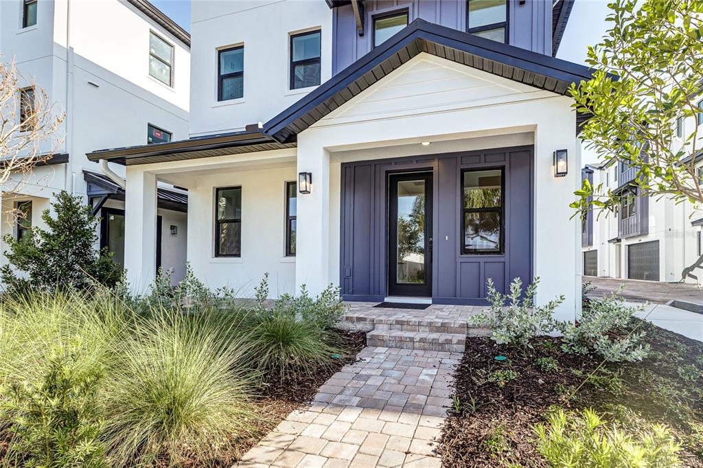 A modern white and dark blue house exterior with a brick walkway and front porch — 3009 1ST AVENUE N, ST PETERSBURG, FL