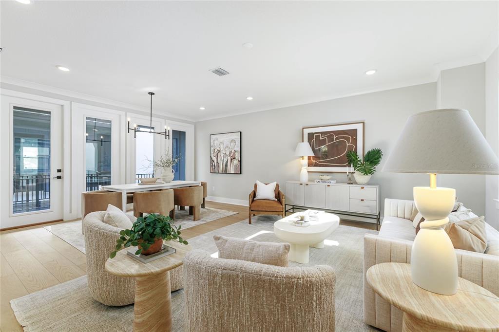 A bright, open-concept living and dining area features neutral furniture, light wood floors, and modern decor — 3009 1ST AVENUE N, ST PETERSBURG, FL