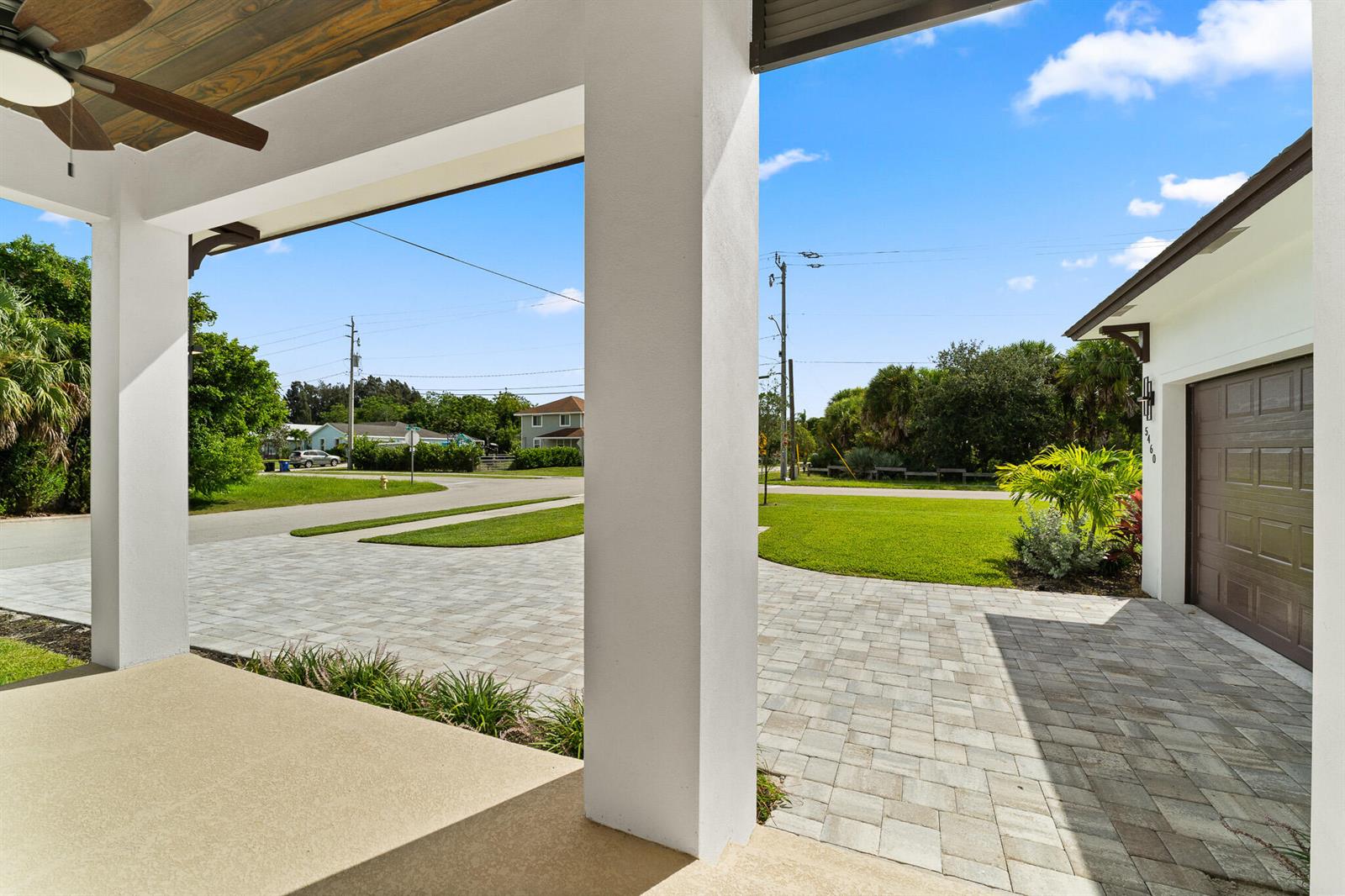 A view from a covered porch looking out onto a paved driveway and front yard — 5460 SE Front Avenue, Stuart FL 34997, STUART, FL
