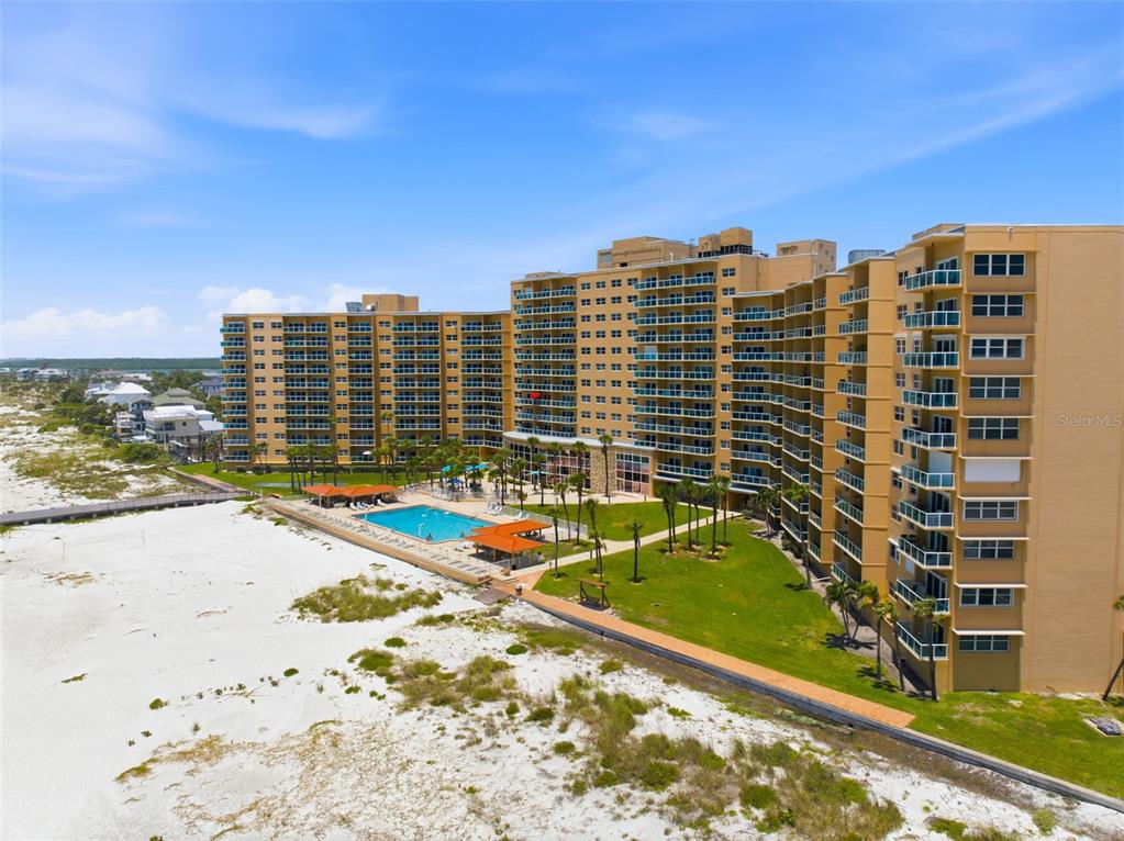 An aerial view of a large beachfront condominium complex with a swimming pool and lawn — 880 MANDALAY AVENUE UNIT C1214, CLEARWATER BEACH, FL