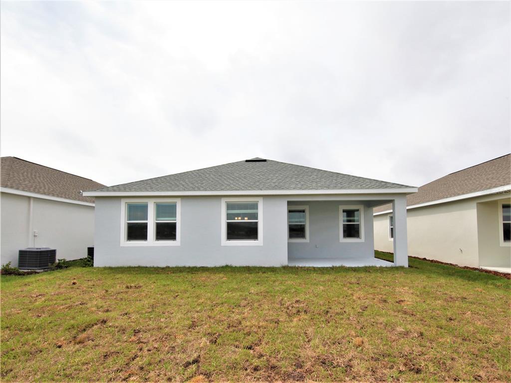 An empty bedroom features beige walls, gray carpet, and a single window with blinds — 4619 RHYTHM ROAD, KISSIMMEE, FL