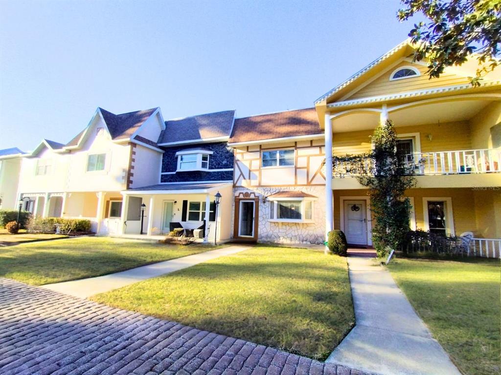 A multi-unit residential building with a mix of yellow siding, stone accents, and balconies — 8830 SW 98 PLACE UNIT M, OCALA, FL