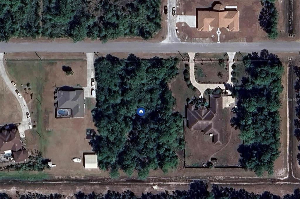 An aerial view shows a wooded, undeveloped residential lot situated between two existing houses — MAJESTIC STREET, ORLANDO, FL