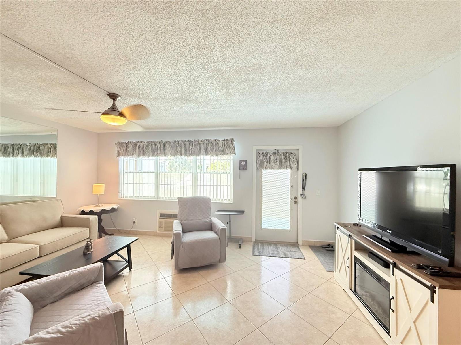 A living room features tile floors, a ceiling fan, a television console, and neutral furniture — 53 Markham C # 53, Deerfield Beach FL 33442, DEERFIELD BEACH, FL